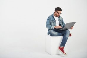 handsome-young-man-with-laptop-and-check-his-timetable-on-white (1)